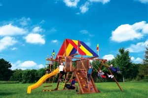 A beautiful sunny day with perfect blue skies overhead a playground set. There are kids swinging and climbing.